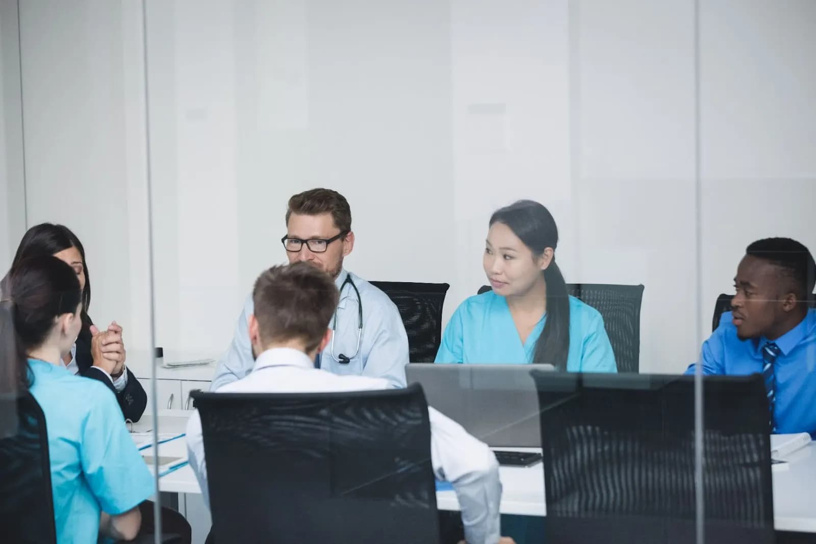 Clinical and administrative staff meeting around a conference table