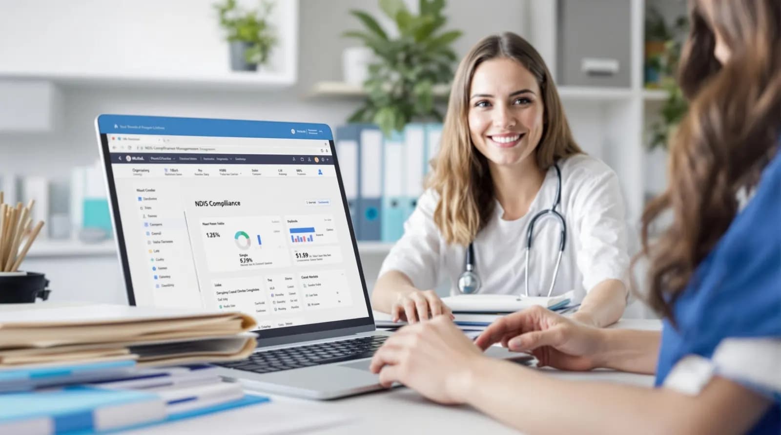 Smiling health worker at a desk with a laptop showing a compliance dashboard