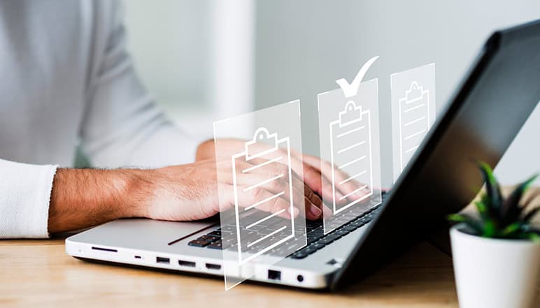 Person typing on laptop with digital checklist icons, symbolizing documentation management and compliance for NDIS services by Compliance Care.